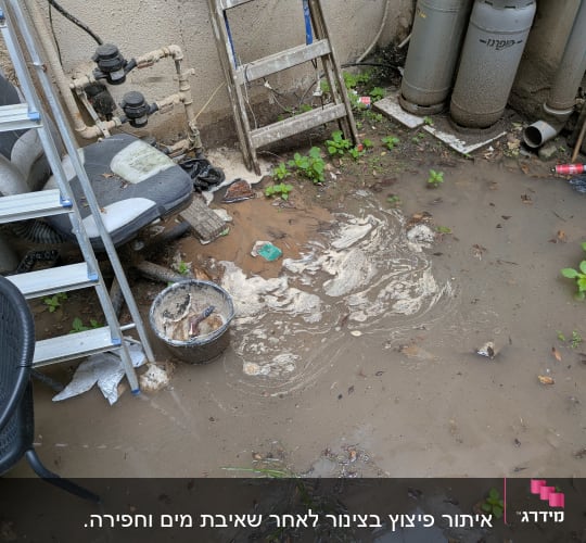שטח חיצוני עם שלולית בוץ, סולם, כיסא וצינורות גז.